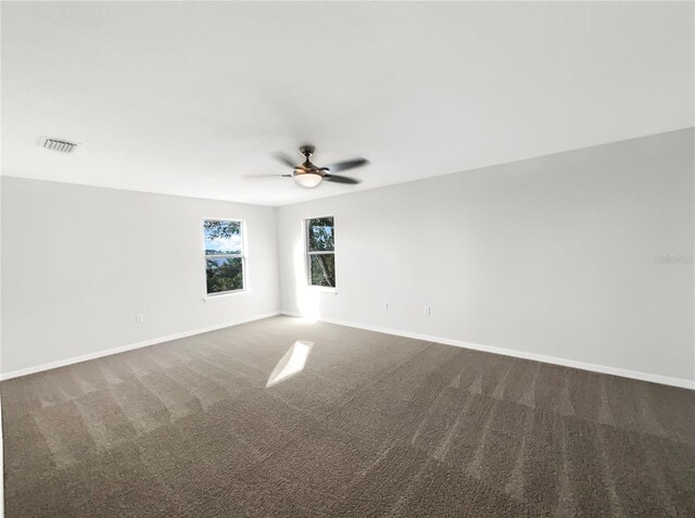 carpeted spare room with ceiling fan