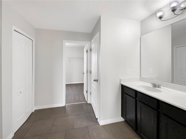 bathroom featuring tile patterned flooring, vanity, and a textured ceiling