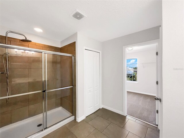 bathroom featuring tile patterned flooring and a shower with door