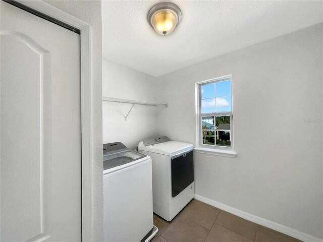 clothes washing area featuring tile patterned flooring and independent washer and dryer