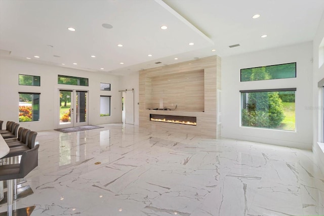 living room with a large fireplace, tile walls, french doors, and tile floors