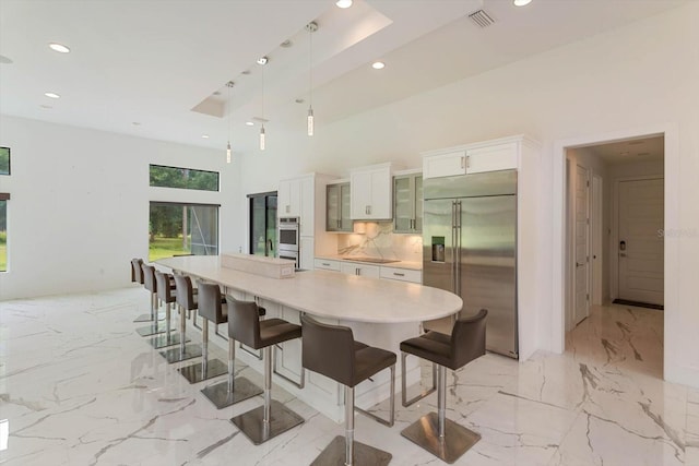 dining space with a towering ceiling and light tile flooring