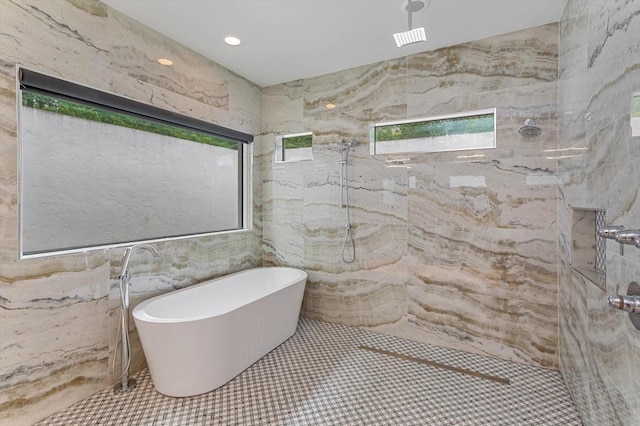 bathroom with shower with separate bathtub, tile walls, and tile floors