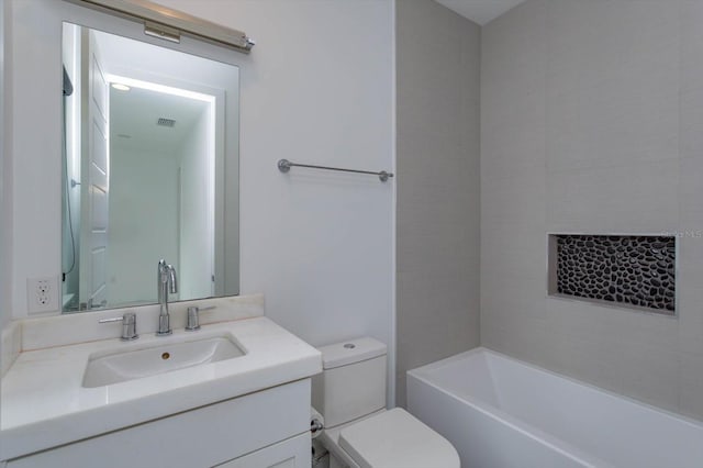 full bathroom featuring tiled shower / bath, vanity, and toilet