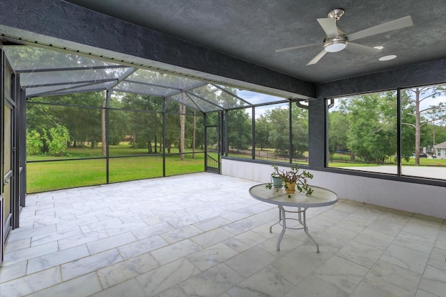 unfurnished sunroom with ceiling fan