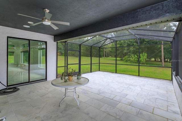 unfurnished sunroom with ceiling fan