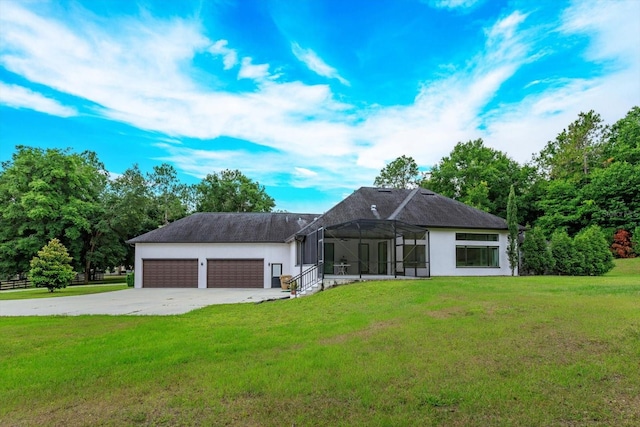 back of house featuring a garage and a lawn