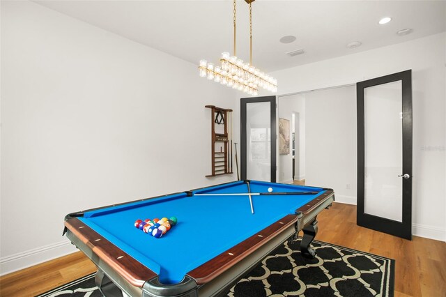 rec room with a chandelier, hardwood / wood-style floors, and pool table