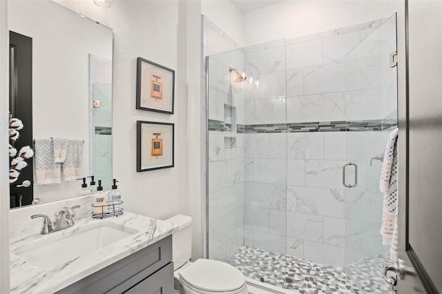 bathroom featuring vanity, toilet, and walk in shower