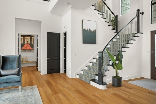 stairs with a high ceiling and hardwood / wood-style flooring