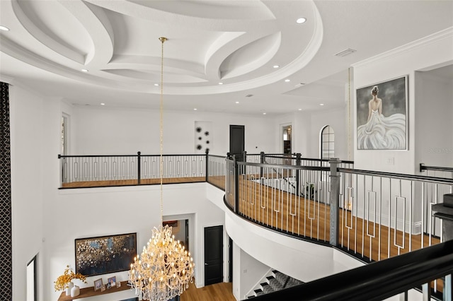 hallway featuring ornamental molding, wood-type flooring, coffered ceiling, and an inviting chandelier