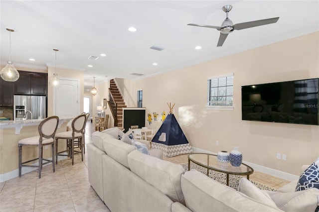 living room featuring ceiling fan, crown molding, and light tile floors