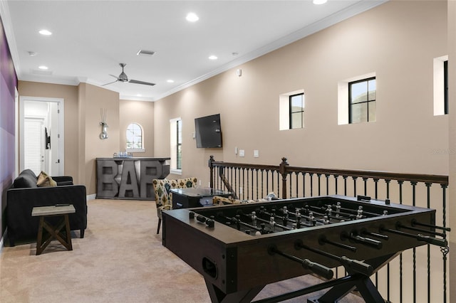 recreation room featuring a wealth of natural light, ceiling fan, crown molding, and light carpet