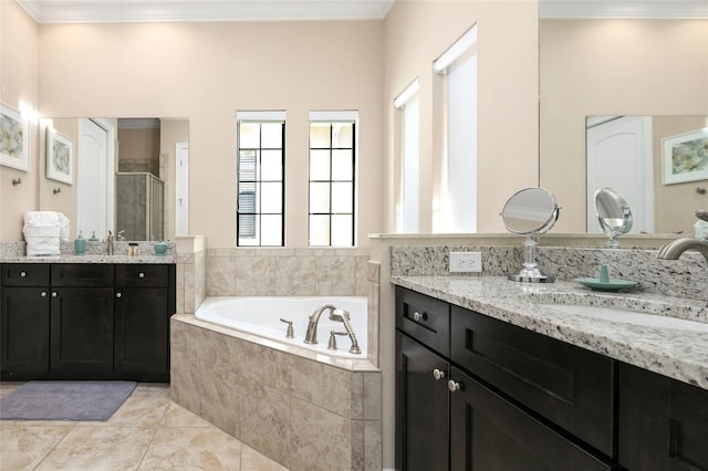 bathroom with tile floors, tiled bath, crown molding, and oversized vanity