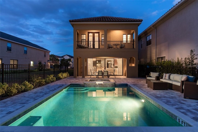 exterior space featuring an outdoor hangout area, a patio area, a balcony, and a fenced in pool