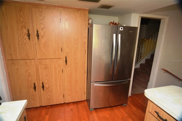 kitchen featuring stainless steel refrigerator and light hardwood / wood-style flooring