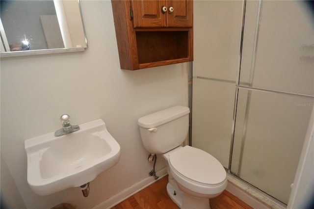 bathroom featuring walk in shower, sink, wood-type flooring, and toilet