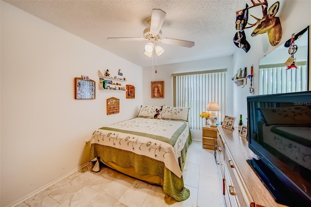 bedroom featuring ceiling fan and a textured ceiling