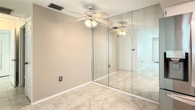 interior space with ceiling fan and a textured ceiling