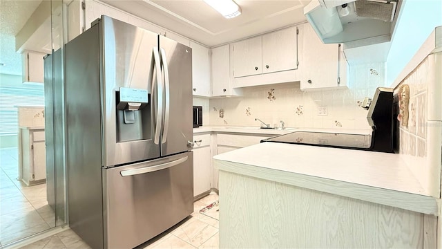 kitchen featuring sink, stainless steel fridge, and white cabinets