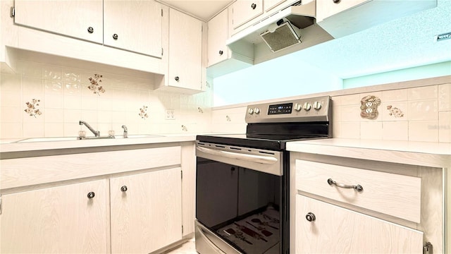 kitchen featuring stainless steel range with electric stovetop, sink, and backsplash