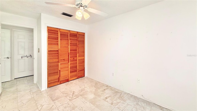 unfurnished bedroom featuring ceiling fan, a closet, and a textured ceiling