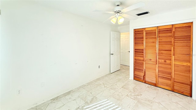 unfurnished bedroom with ceiling fan and a closet