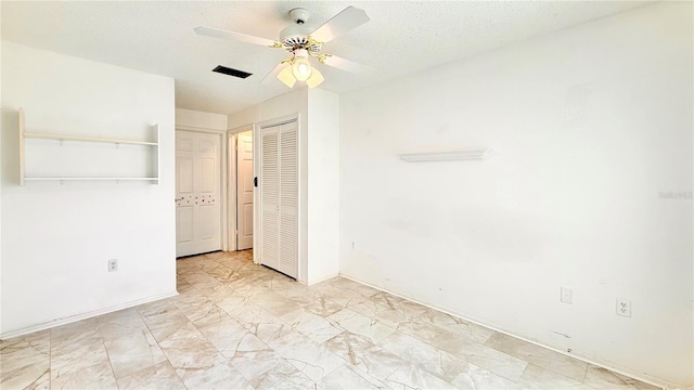 unfurnished bedroom with ceiling fan and a textured ceiling