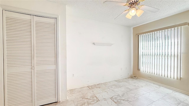 unfurnished bedroom with ceiling fan, a closet, and a textured ceiling