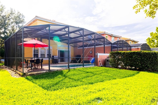 back of property featuring a fenced in pool, glass enclosure, a yard, and a patio