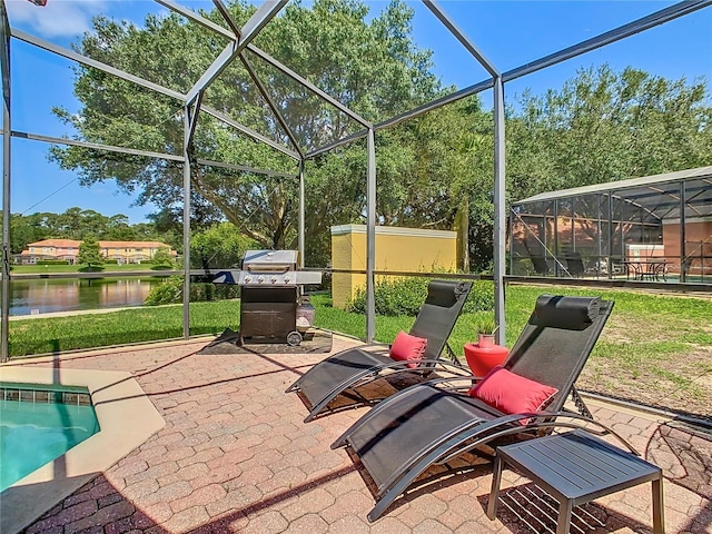 view of patio featuring glass enclosure and a water view