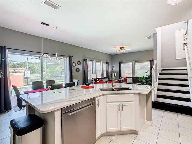 kitchen featuring white cabinets, a center island with sink, sink, stainless steel dishwasher, and light tile patterned floors