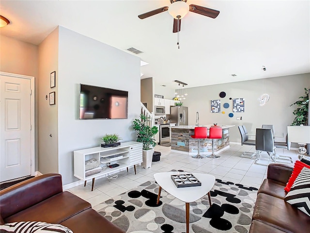 tiled living room with ceiling fan and sink