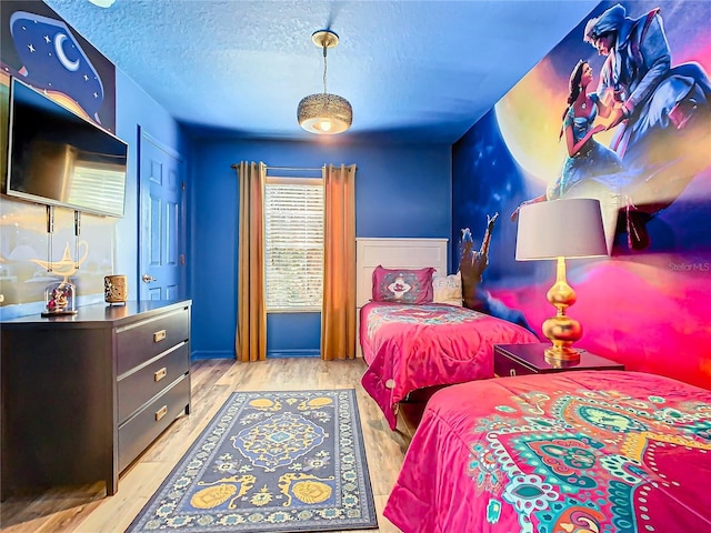 bedroom featuring a textured ceiling and light hardwood / wood-style flooring