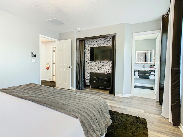 bedroom featuring light wood-type flooring and a textured ceiling