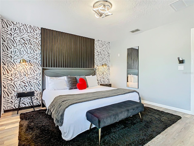 bedroom with light wood-type flooring and a textured ceiling