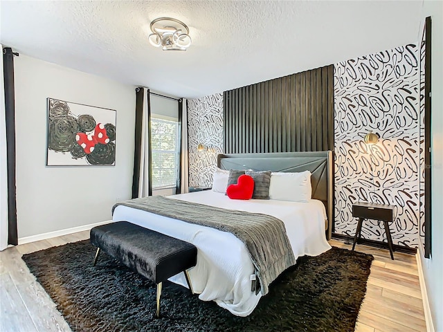 bedroom with light wood-type flooring and a textured ceiling