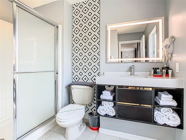 bathroom featuring tile patterned floors, vanity, toilet, and a shower with door