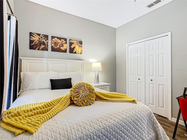 bedroom with dark hardwood / wood-style floors and a closet