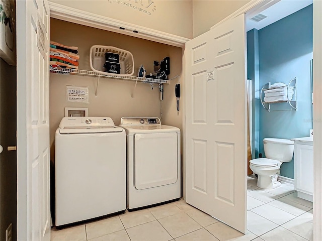 washroom featuring washing machine and dryer and light tile patterned floors