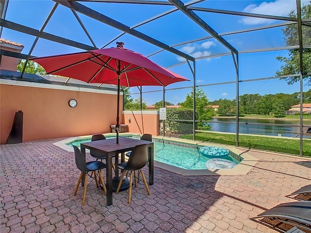 view of swimming pool featuring a patio, a water view, and glass enclosure