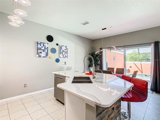 kitchen featuring dishwasher, an island with sink, decorative light fixtures, and light tile patterned floors