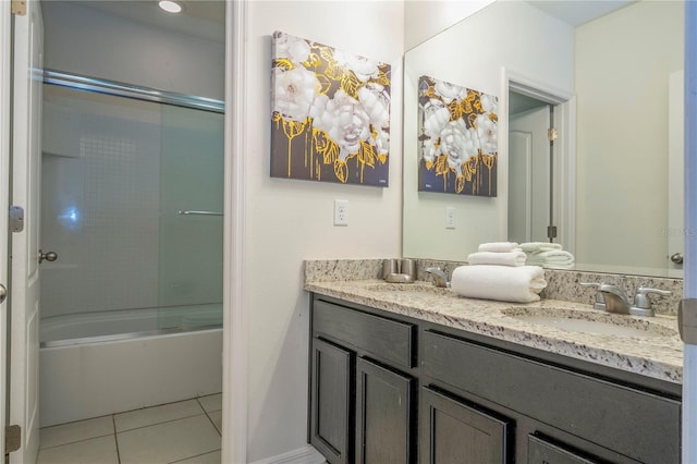 bathroom featuring tile floors, dual bowl vanity, and shower / bath combination with glass door