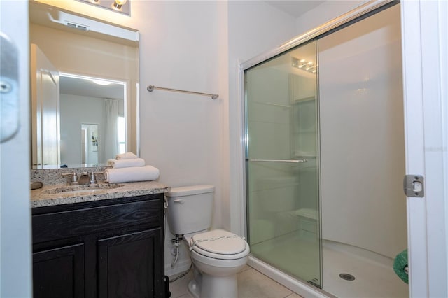 bathroom with a shower with shower door, toilet, tile floors, and large vanity