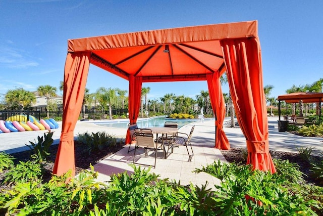 view of terrace with a community pool and a gazebo