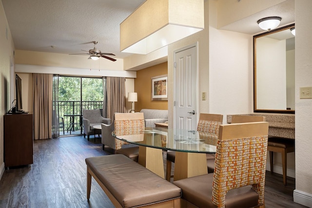 dining area with ceiling fan, dark wood-type flooring, and a textured ceiling