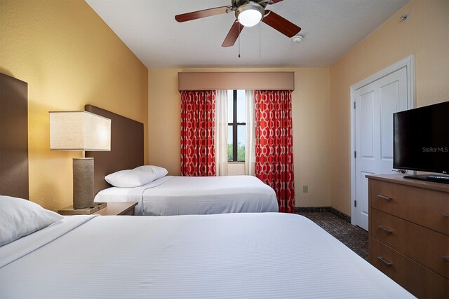 bedroom with dark colored carpet and ceiling fan