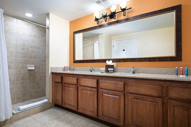 bathroom featuring curtained shower, tile patterned flooring, vanity, and a textured ceiling