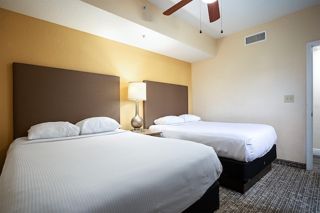 bedroom with ceiling fan and dark colored carpet