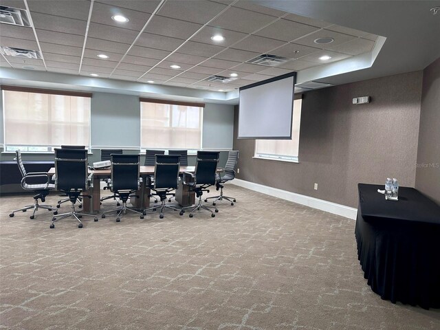 carpeted office space featuring a paneled ceiling